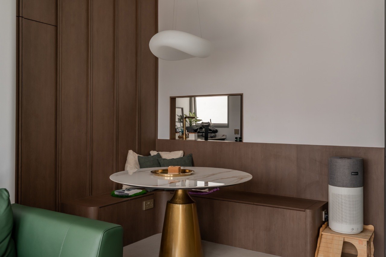 A Green Thread — curved dining banquette against full-height walnut cabinetry
