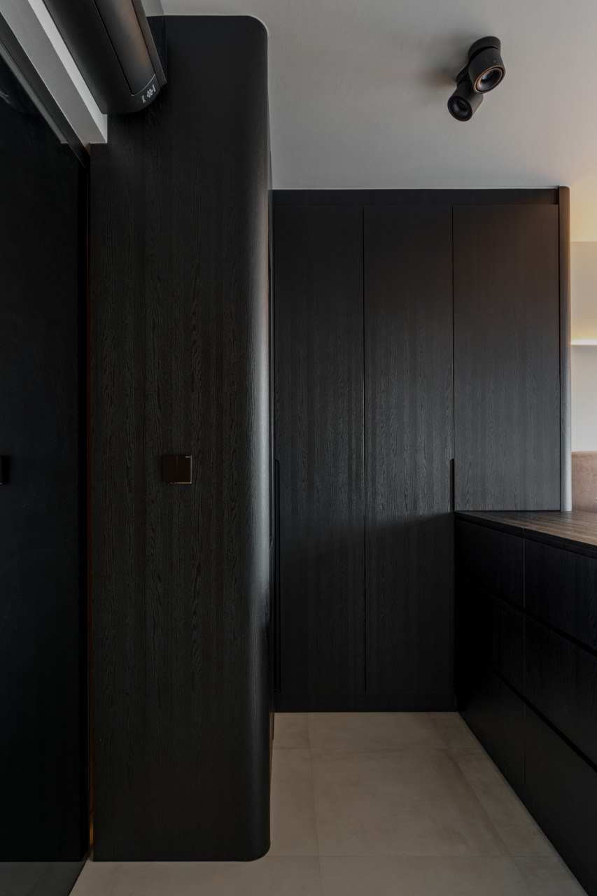 Ridge in Contrast — full-height dark timber storage and bedroom threshold