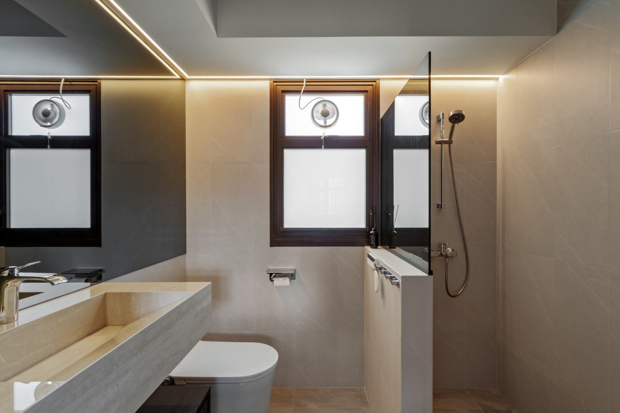 Ridge in Contrast — bathroom with pale stone surfaces and warm lighting